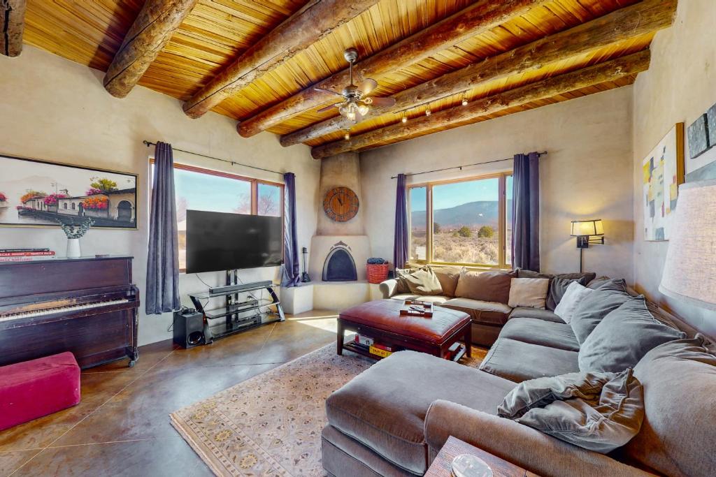 a living room with a couch and a flat screen tv at Pow Days Taos in Taos