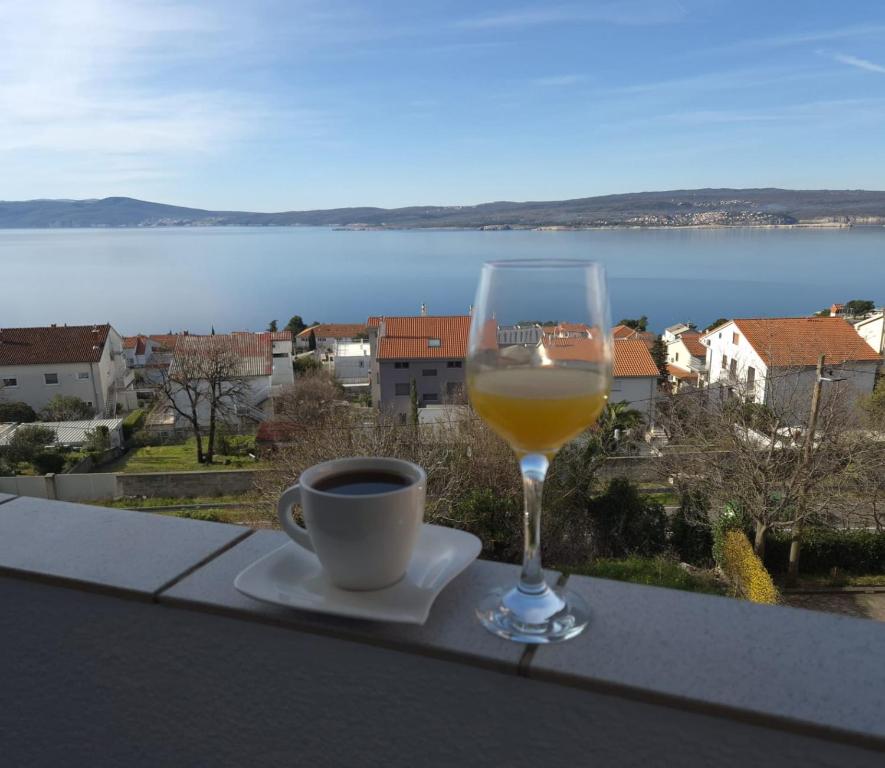 - un verre de vin et une tasse de café sur le balcon dans l'établissement Apartman Lopar Crikvenica, à Crikvenica