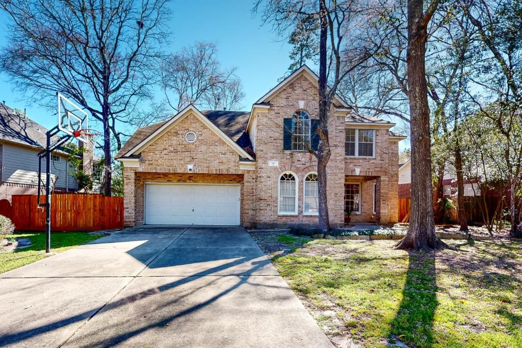a large brick house with a white garage at The Woodlands Retreat in The Woodlands