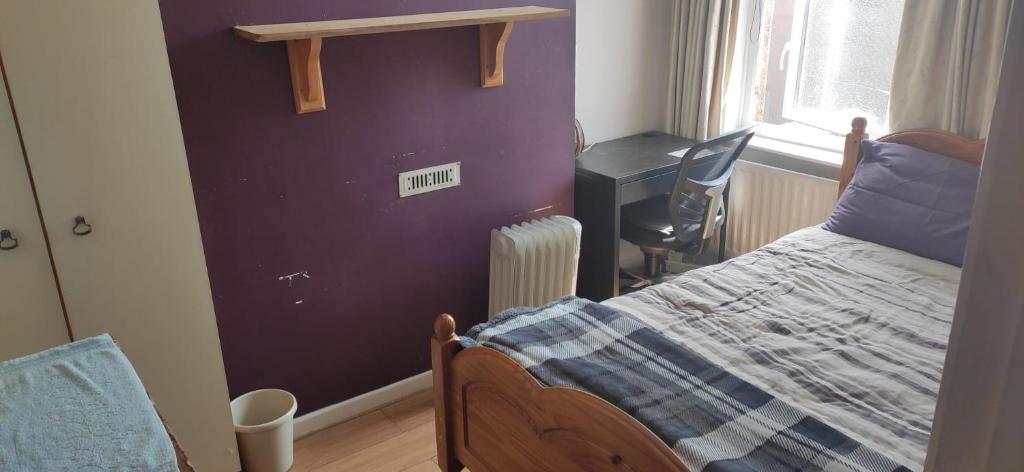 a bedroom with a bed and a desk and a window at CASTLETON in Belfast