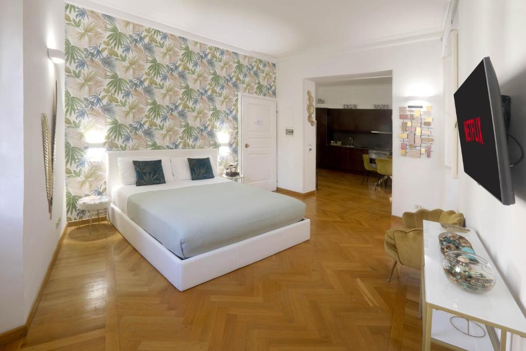 a bedroom with a large white bed and a living room at Residenza al Colosseo in Rome