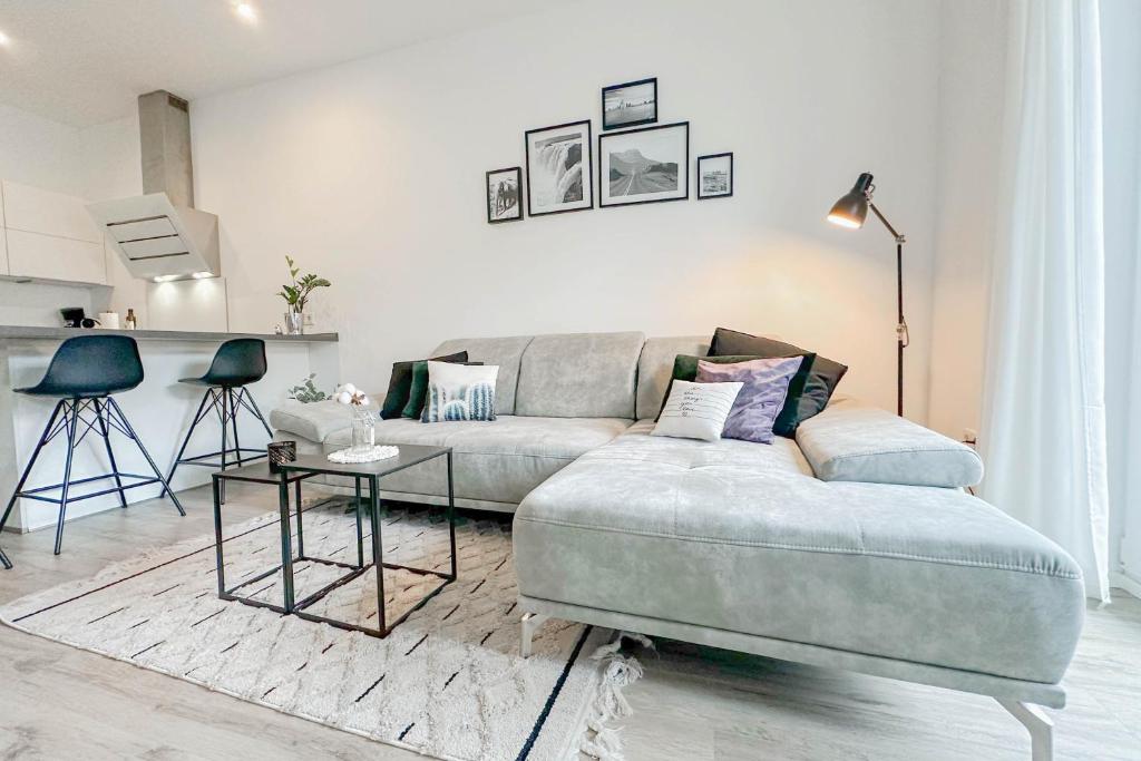 Modernes Trierer CityLoft mit großem Balkon في ترير: غرفة معيشة مع أريكة وطاولة