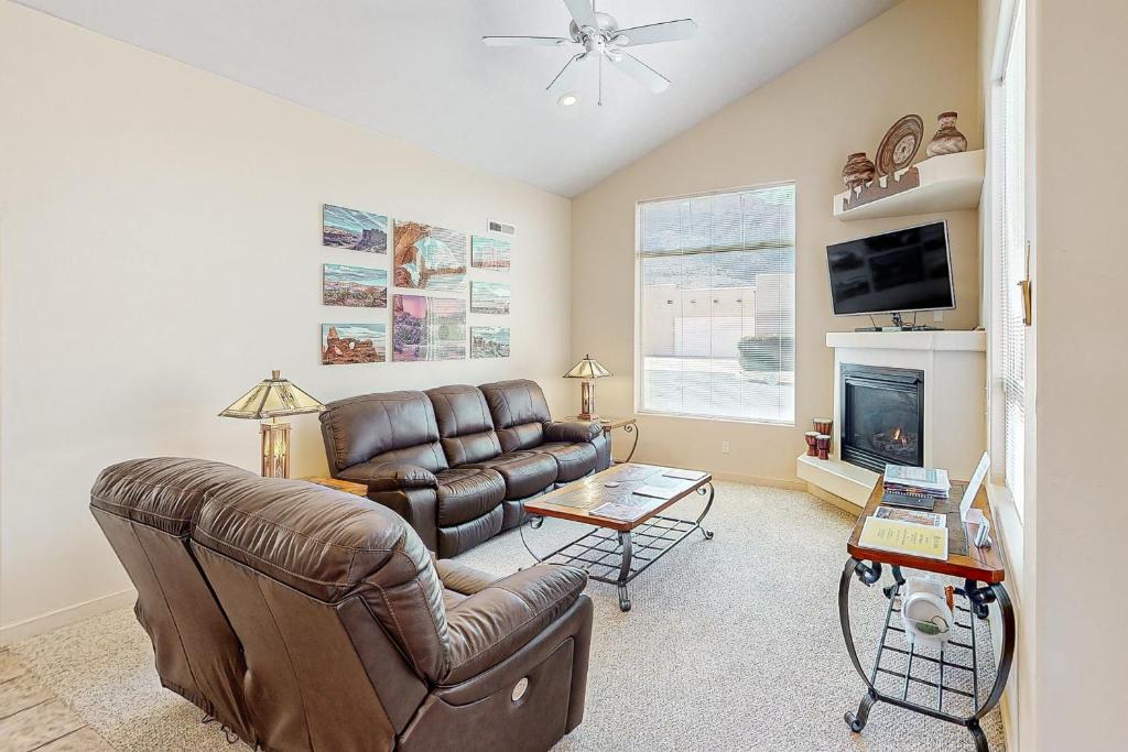 a living room with a leather couch and a fireplace at Rim Village U4 in Moab