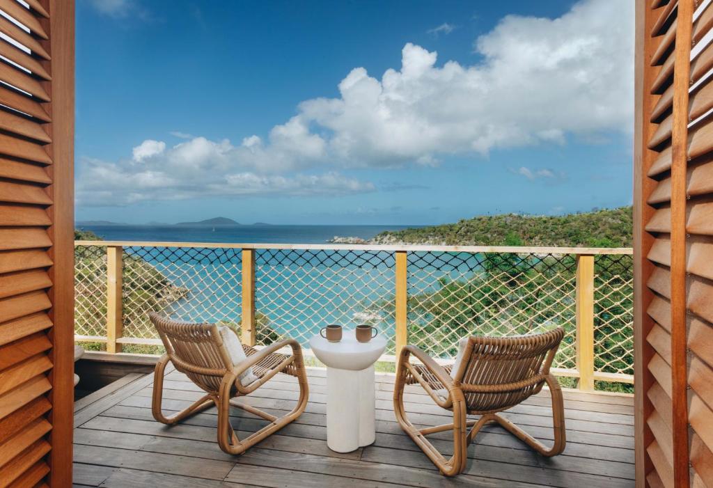 2 sillas y una mesa en una terraza con vistas al océano en Lovango Resort and Beach Club, en Cruz Bay