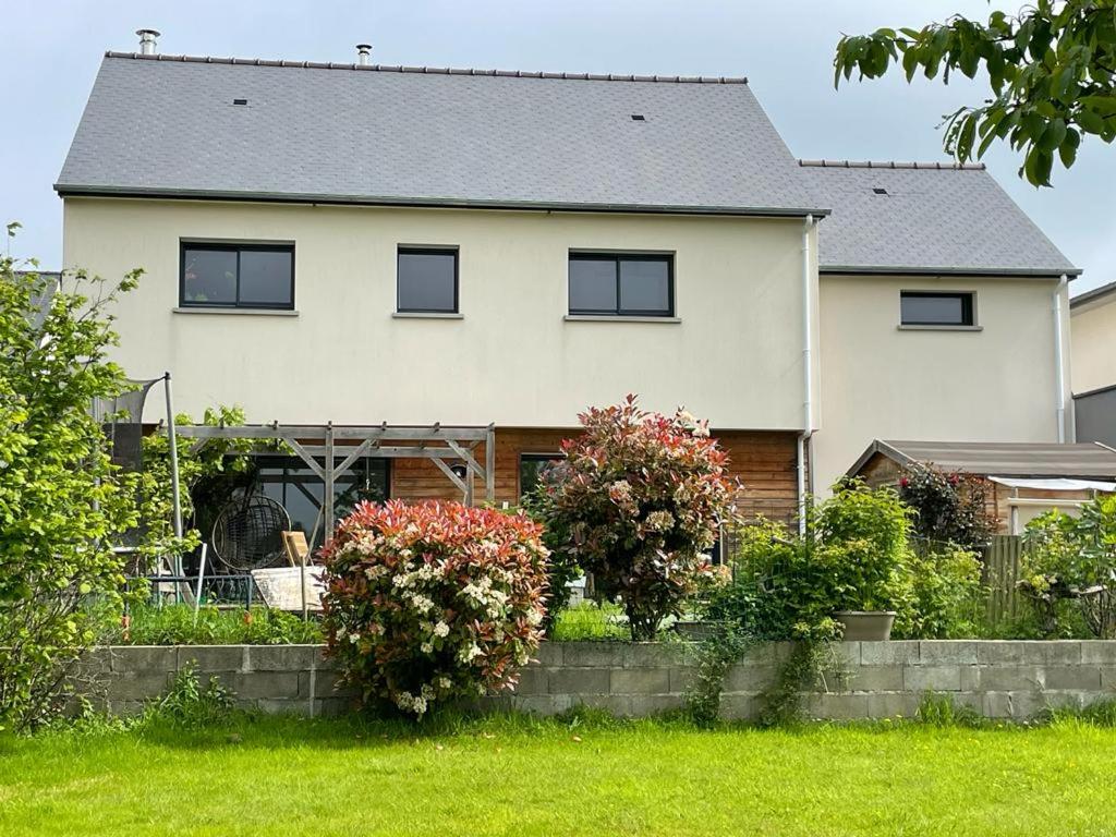een wit huis met ramen en bloemen in een tuin bij An ti bihan in Liffré