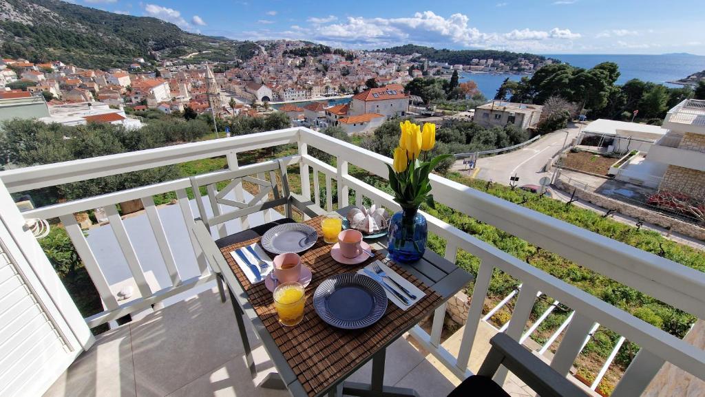 a table on a balcony with a view of a city at Vila Luka 2 in Hvar
