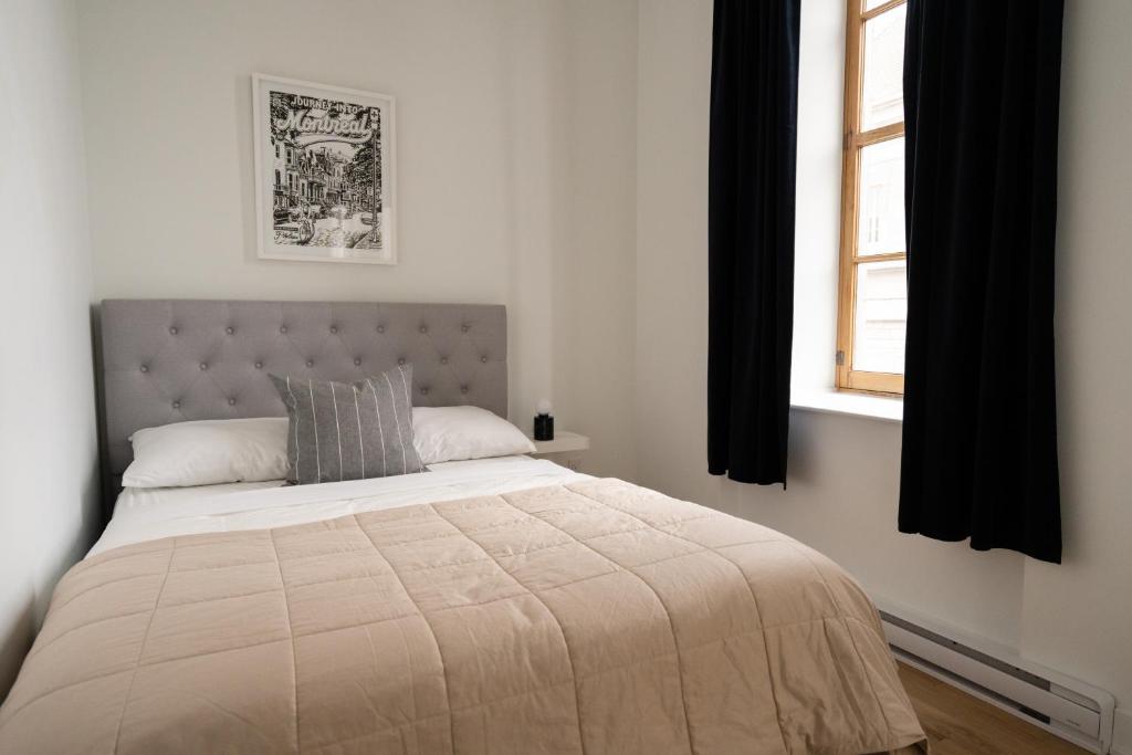 a bedroom with a large bed with a window at Maison Rasco by Luxury In Transit in Montréal