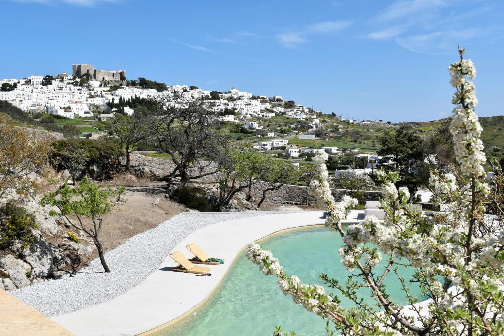 duas pessoas deitadas ao lado de uma piscina em Villa Alexandra em Patmos