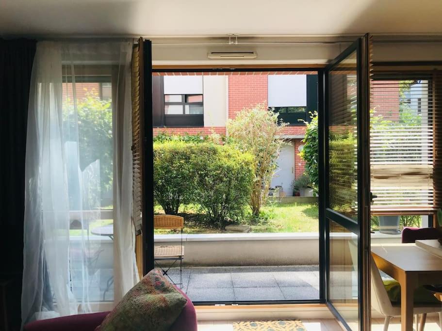 d'un salon avec une porte coulissante en verre s'ouvrant sur une terrasse. dans l'établissement Arena Bercy JO - Paris Est - 3p lumineux terrasse, à Montreuil