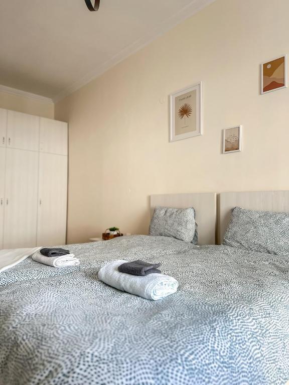 a bedroom with a bed with two towels on it at Downtown Hostel AXD in Alexandroupoli