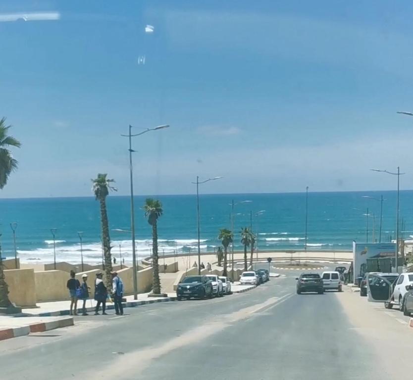 pessoas andando por uma rua perto da praia em Cammar Appartement em Kenitra
