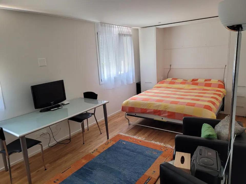 Schlafzimmer mit einem Bett und einem Schreibtisch mit einem Computer in der Unterkunft Vreneli in Mitlödi