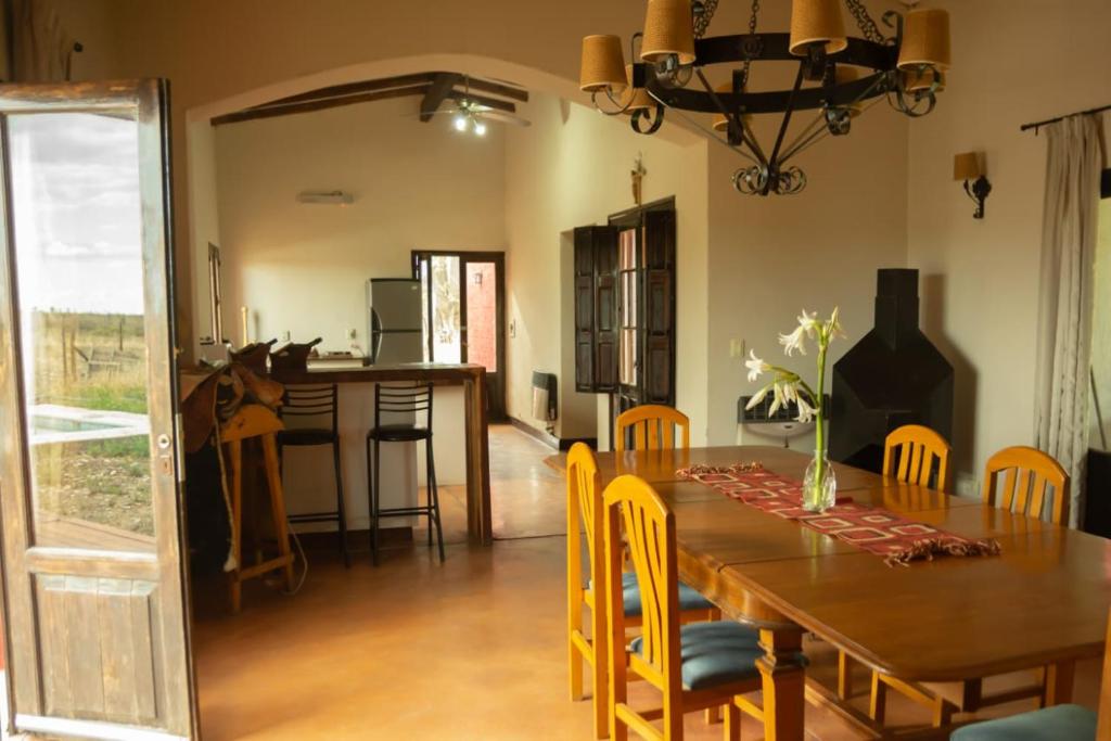 a dining room with a wooden table and chairs at La Martina in Los Árboles