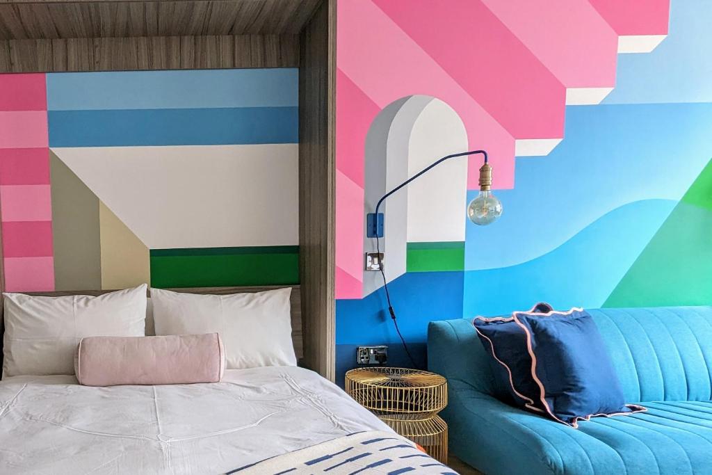 a bedroom with a bed and a colorful wall at I Should Cocoa (York) - Seebohm in York