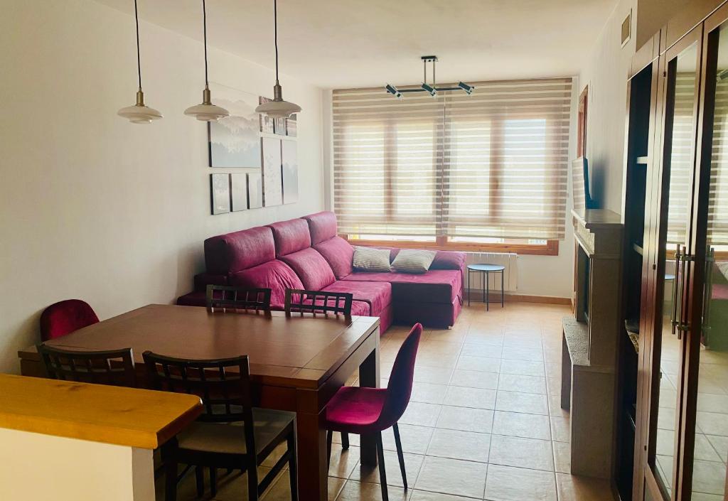 - un salon avec un canapé rose et une table dans l'établissement Apto en Campo Valle de Benasque 2 dormitorios Wifi, à Campo