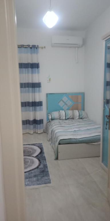 - une chambre avec un lit dans une pièce dotée d'une fenêtre dans l'établissement شقه امام كلية الطب, à Alexandrie