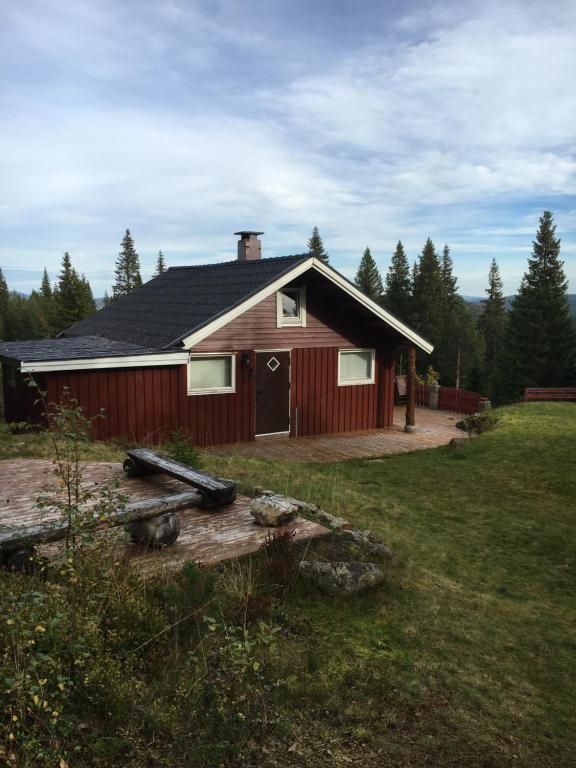 una casa roja con porche y patio en Selmoen by Norgesbooking - secluded location en Fannrem