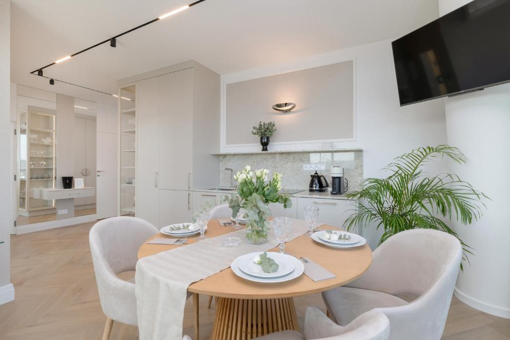 una cucina e una sala da pranzo con tavolo e sedie di Wave Międzyzdroje Luxury Apartment MORENORENT a Międzyzdroje