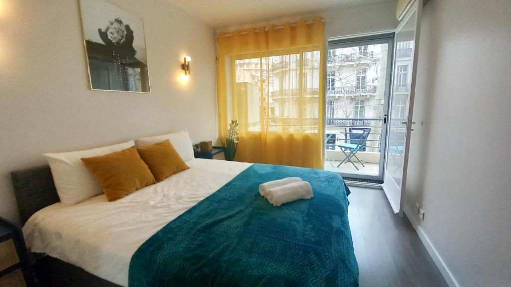 une chambre avec un lit et une grande fenêtre dans l'établissement Palais Carnot central apartment with balcony and A C, à Cannes