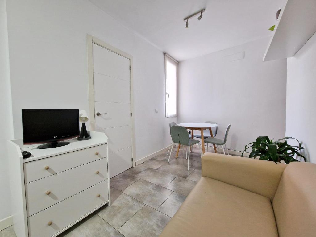 a living room with a couch and a tv and a table at San Buenaventura Vistillas apartamento para dos in Madrid