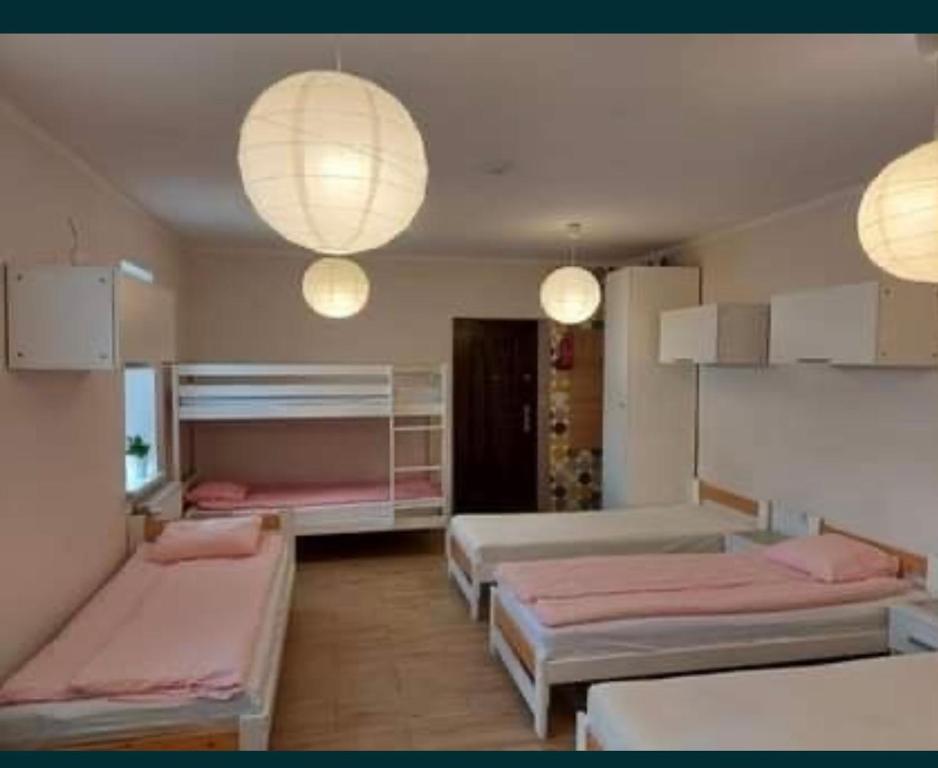 um quarto com três camas e luzes e candeeiros em Studio - noclegi pracownicze , max 7 osób em Varsóvia
