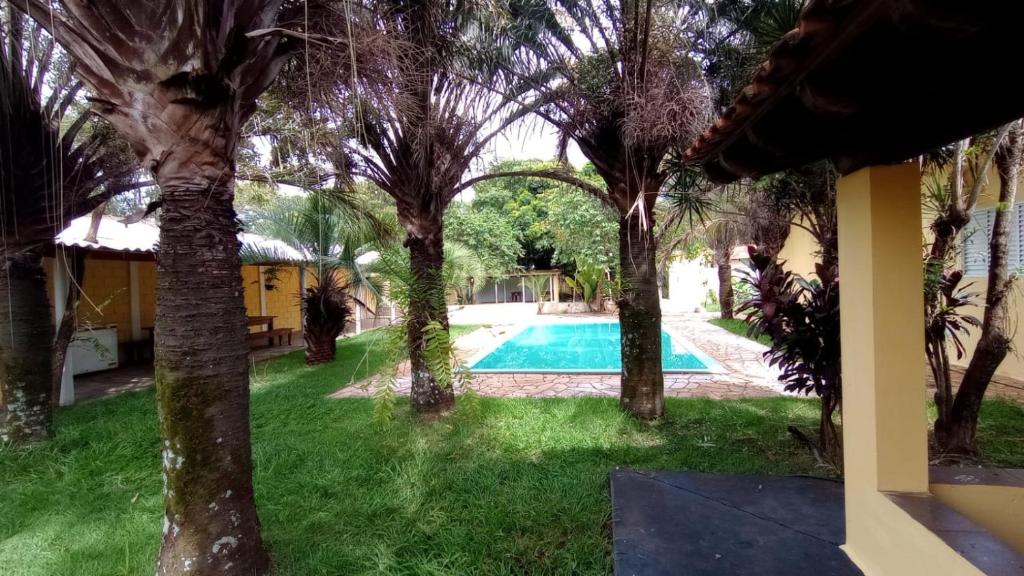 uitzicht op een tuin met bomen en een zwembad bij Chácara Ben te vi in Ribeirão Preto