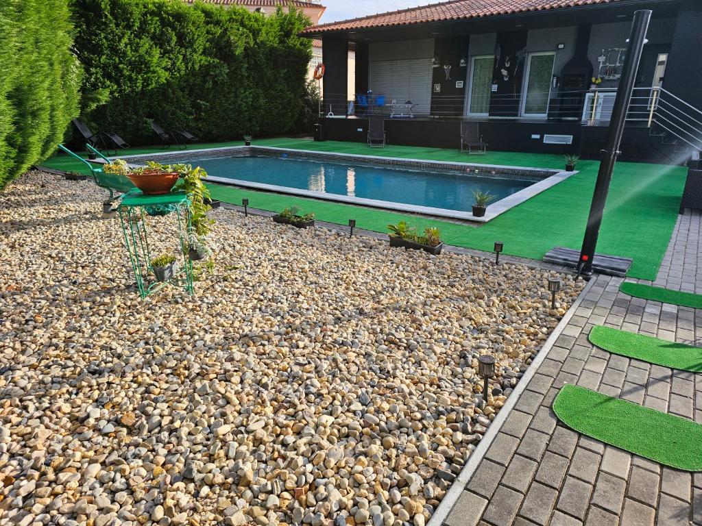 un patio trasero con una piscina con rocas y una casa en Cabeço - Luxury House and Living, en Monte Redondo
