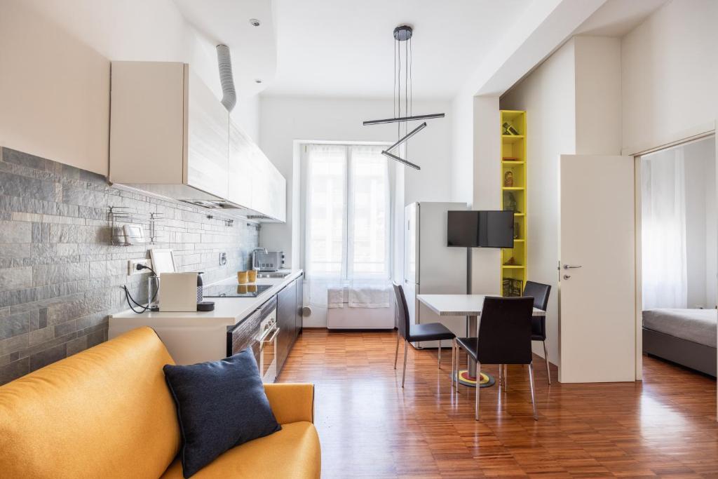 a kitchen and living room with a couch and a table at Memo Apartment in Bologna