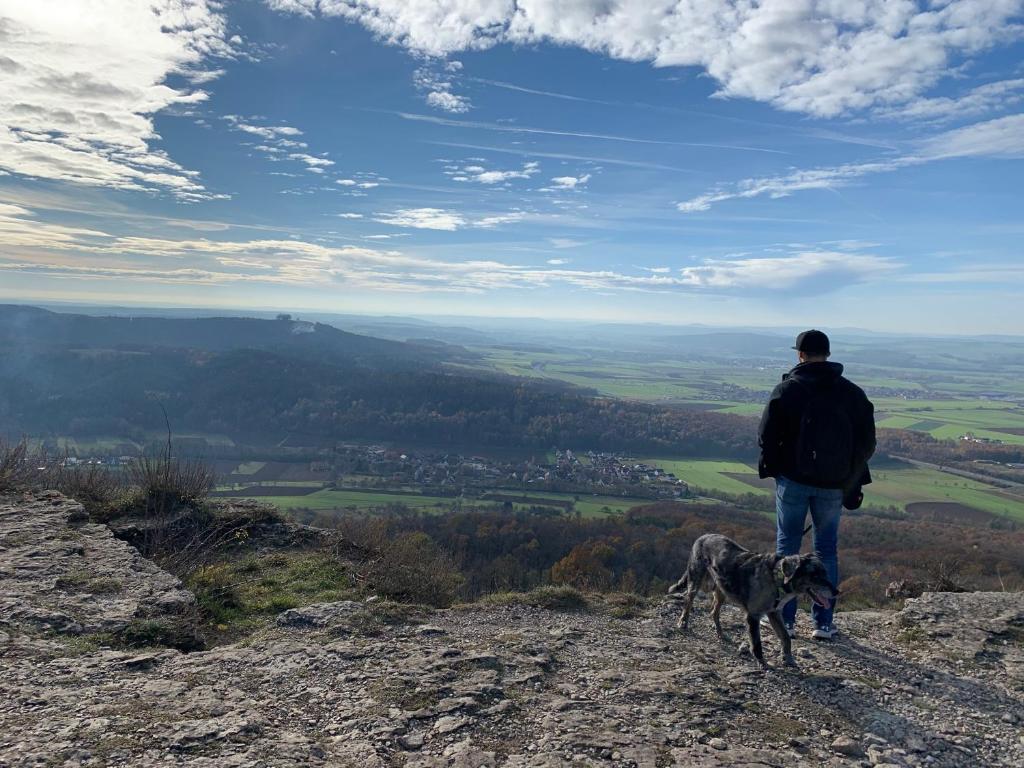 a man and his dog standing on top of a mountain at Ferienwohnung Ulrich Gebauer in Bad Staffelstein
