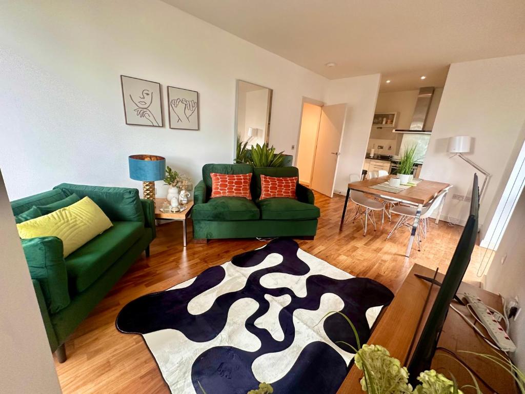 a living room with two green couches and a table at NEW Two Bedroom Apartment with Balcony in London