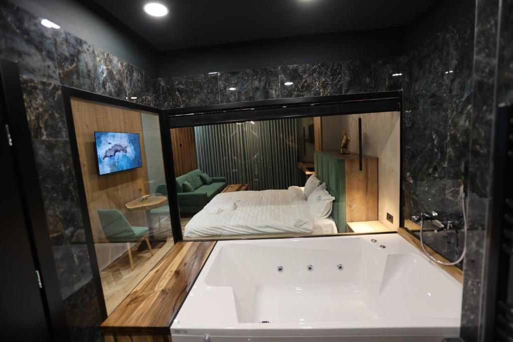 uma banheira num quarto com um quarto em B.G Luxury Suites em Korçë