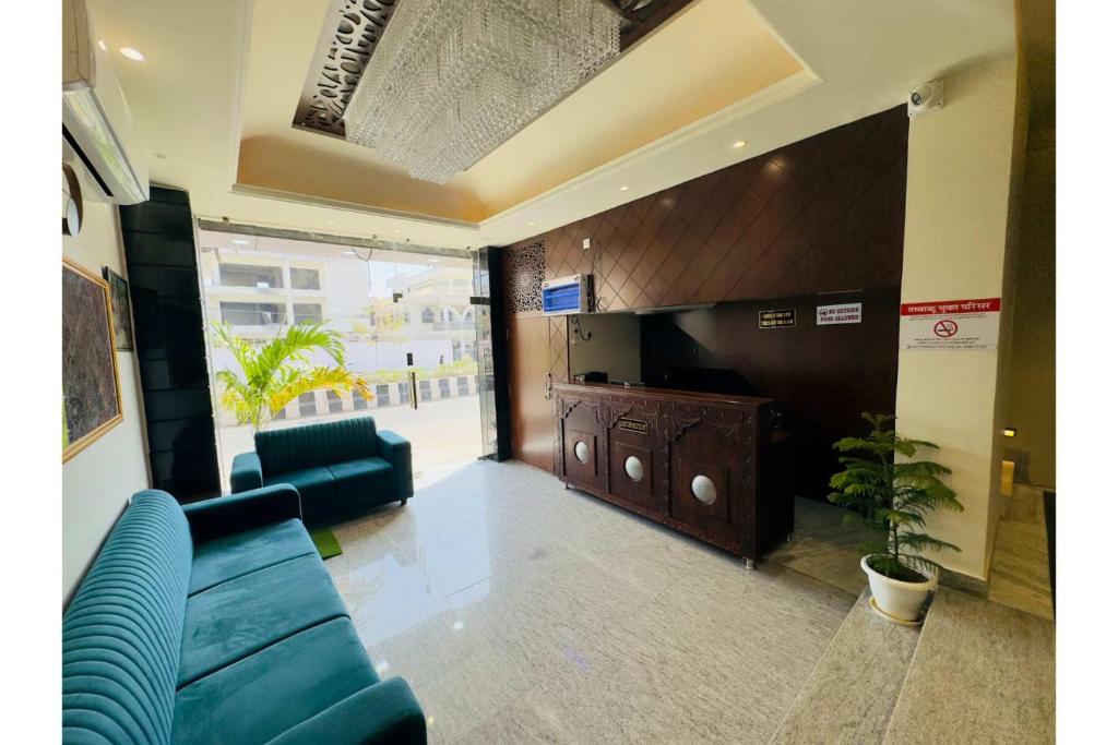 ein Wohnzimmer mit einem blauen Sofa und einem TV in der Unterkunft Hotel Jaipur Dreams in Jaipur
