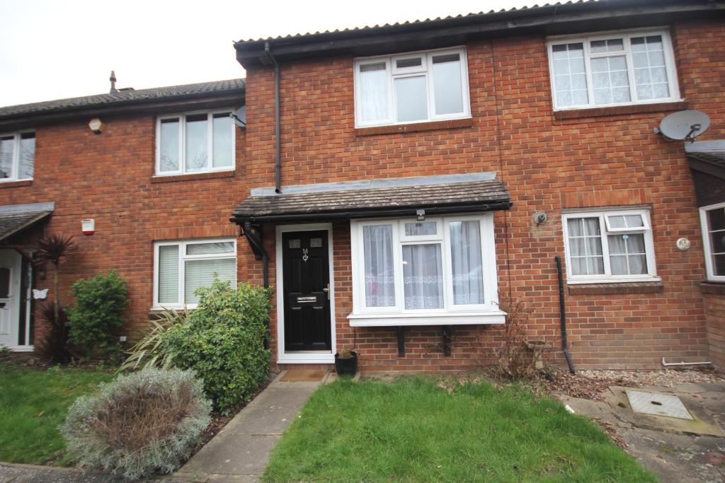 a brick house with a black door and white windows at Lee's Lodge - Modern 2 Bedrooms in Hillingdon