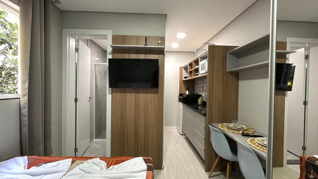 Habitación pequeña con TV y cocina pequeña. en 4- Studio para casal. Ótima Localização, en Curitiba