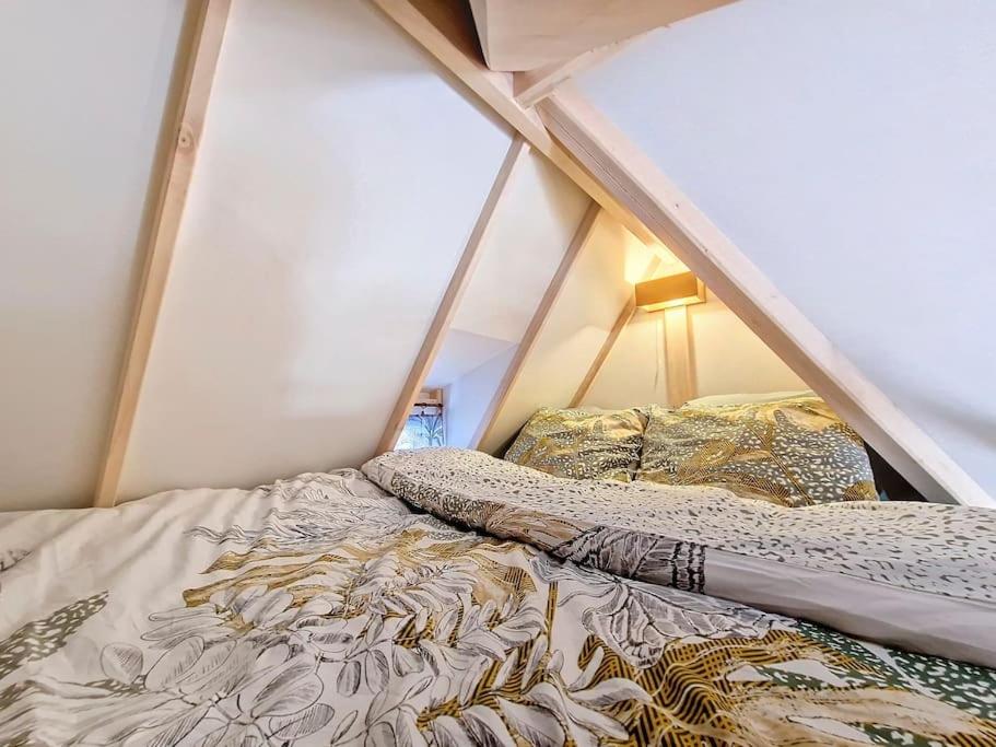 ein Bett in einem Zelt mit zwei Kissen darauf in der Unterkunft Cosy Tiny centre-ville de Nîmes in Nîmes
