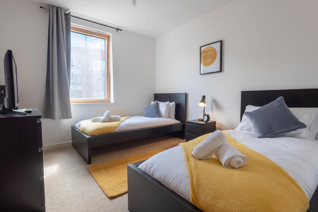 a bedroom with two beds and a tv and a window at Bristol apartment-long stay-April disc-contractors in Bristol