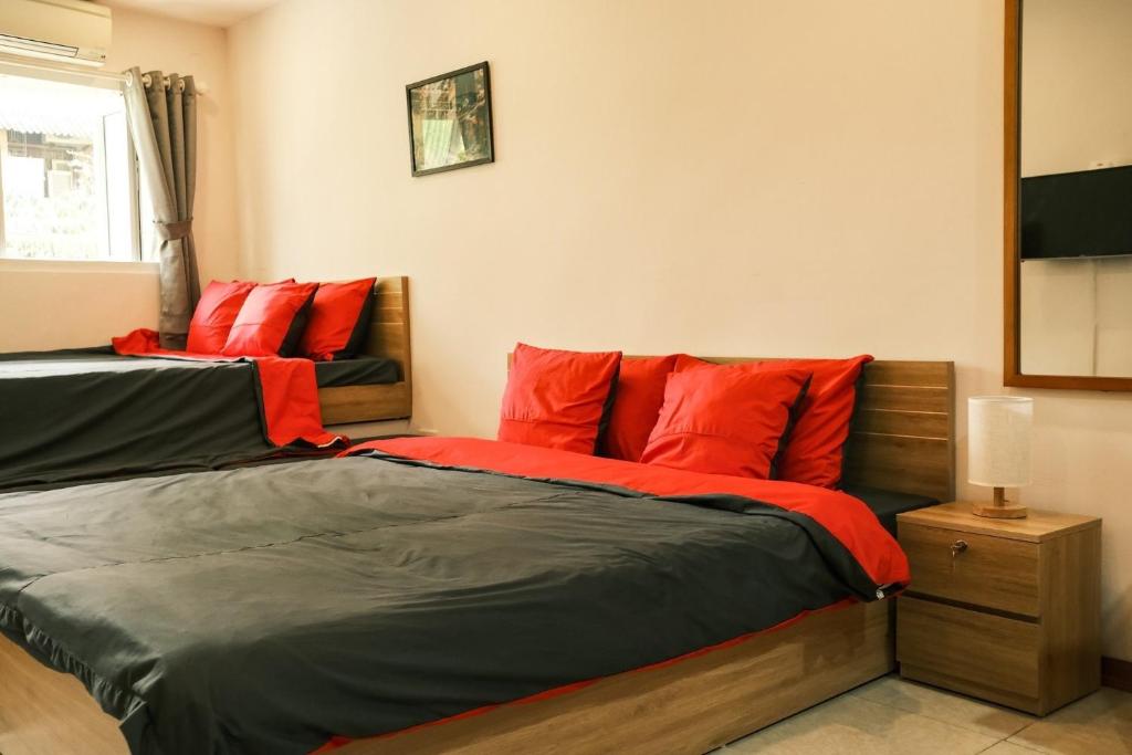 a bedroom with two beds with red pillows at Central Cozy apartment - Beer street 201#301 in Hanoi