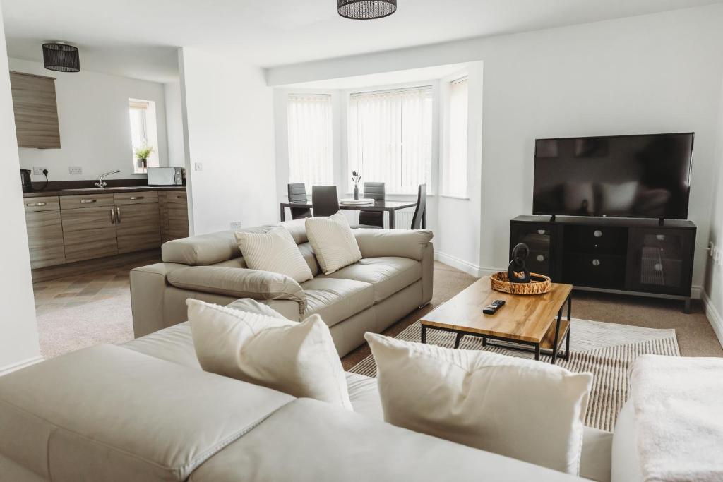 a living room with two couches and a tv at Golden Flatts Apartment in Hartlepool