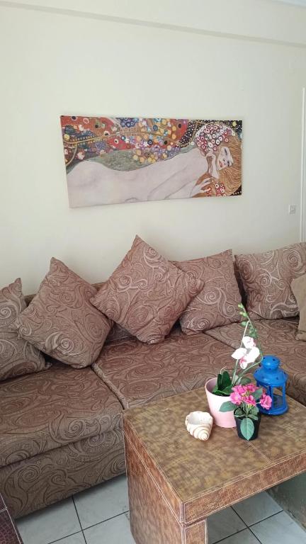 - un salon avec un canapé brun et une table dans l'établissement DINAS Apartment Flogita Beach, à Flogita