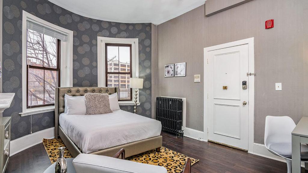 een slaapkamer met een bed, een bureau en een raam bij Premier Suites Bay Village in Boston