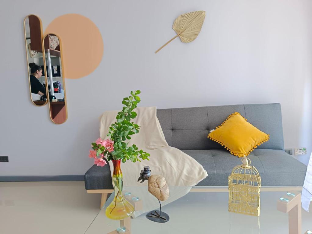uma sala de estar com um sofá azul e um vaso com flores em Vivir en Santiago em Santiago