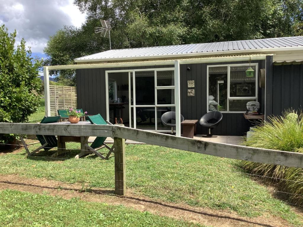 a tiny house with a table in the yard at Wood Pigeon Cottage Pet Friendly Free Breakfast Hauraki Rail Trail 2kms in Waikino
