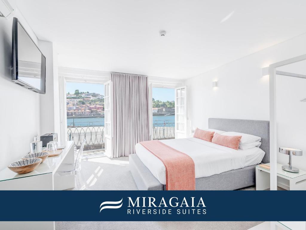a white bedroom with a bed and a balcony at Miragaia - Riverside Suites - Adults Only in Porto