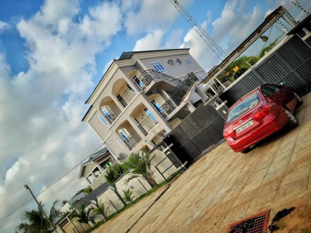 un coche rojo estacionado frente a un edificio en Kojosvilla Luxury Homes, en Kwedonu