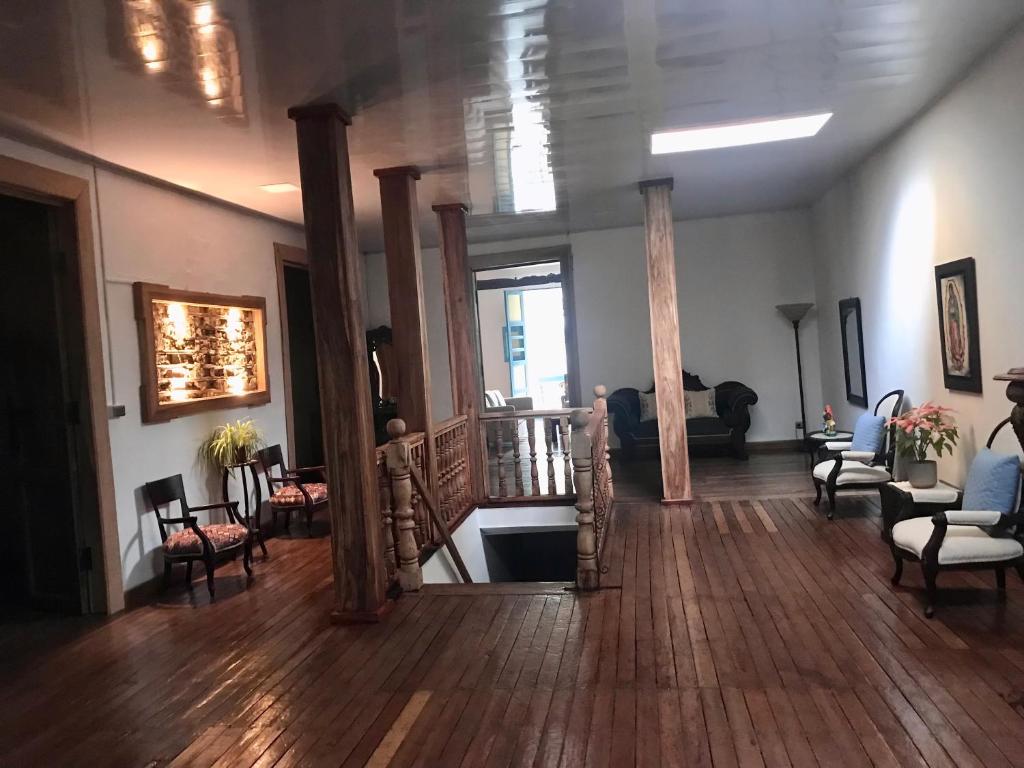 a living room with wooden floors and a room with chairs at 1-Fantástica casa entre montañas in Salamina