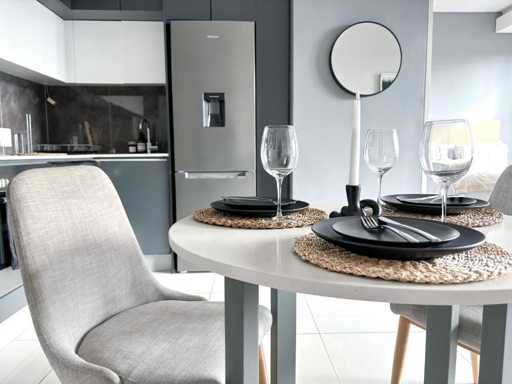 einen Esstisch mit 2 Stühlen und einem Spiegel in der Unterkunft The Capital in Sandton-Luxury aparthotel in Johannesburg