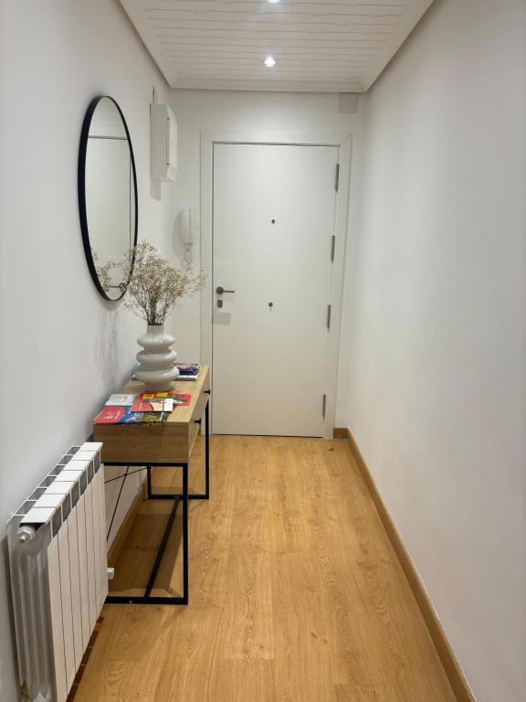 a hallway with a mirror and a table and a door at Céntrico apartamento reformado de dos habitaciones in Logroño
