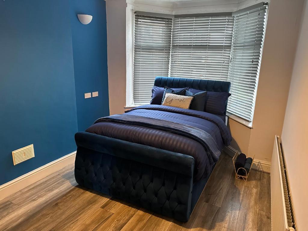 a blue bedroom with a bed and a window at Modern Guest House in Etruria