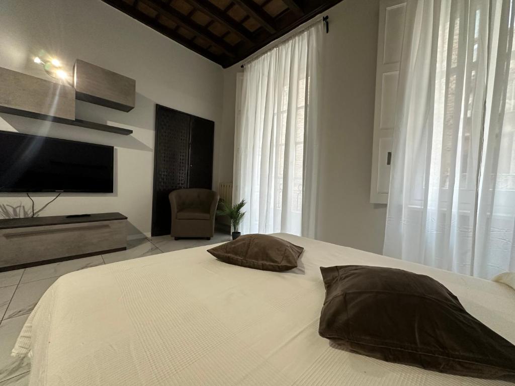 una camera con letto, TV e sedia di Mokai Torino Centro a Torino