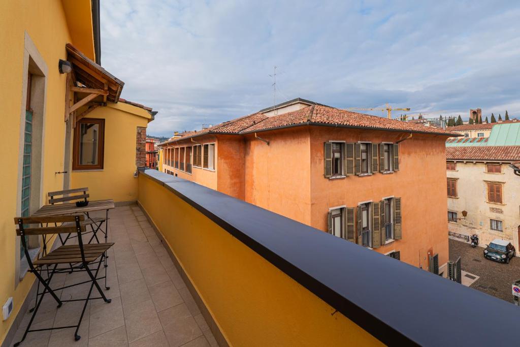 a balcony with a table and chairs on a building at Juliet’s Paradise - Rooftop Terrace in Verona